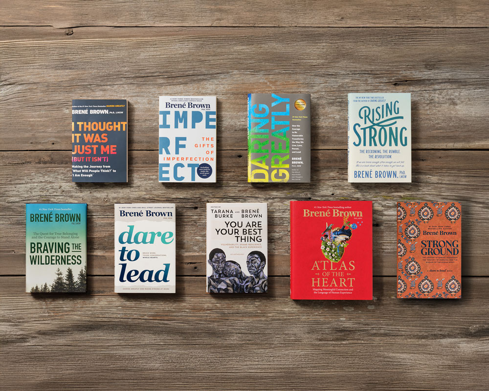 A dark wood table displaying Brené's books