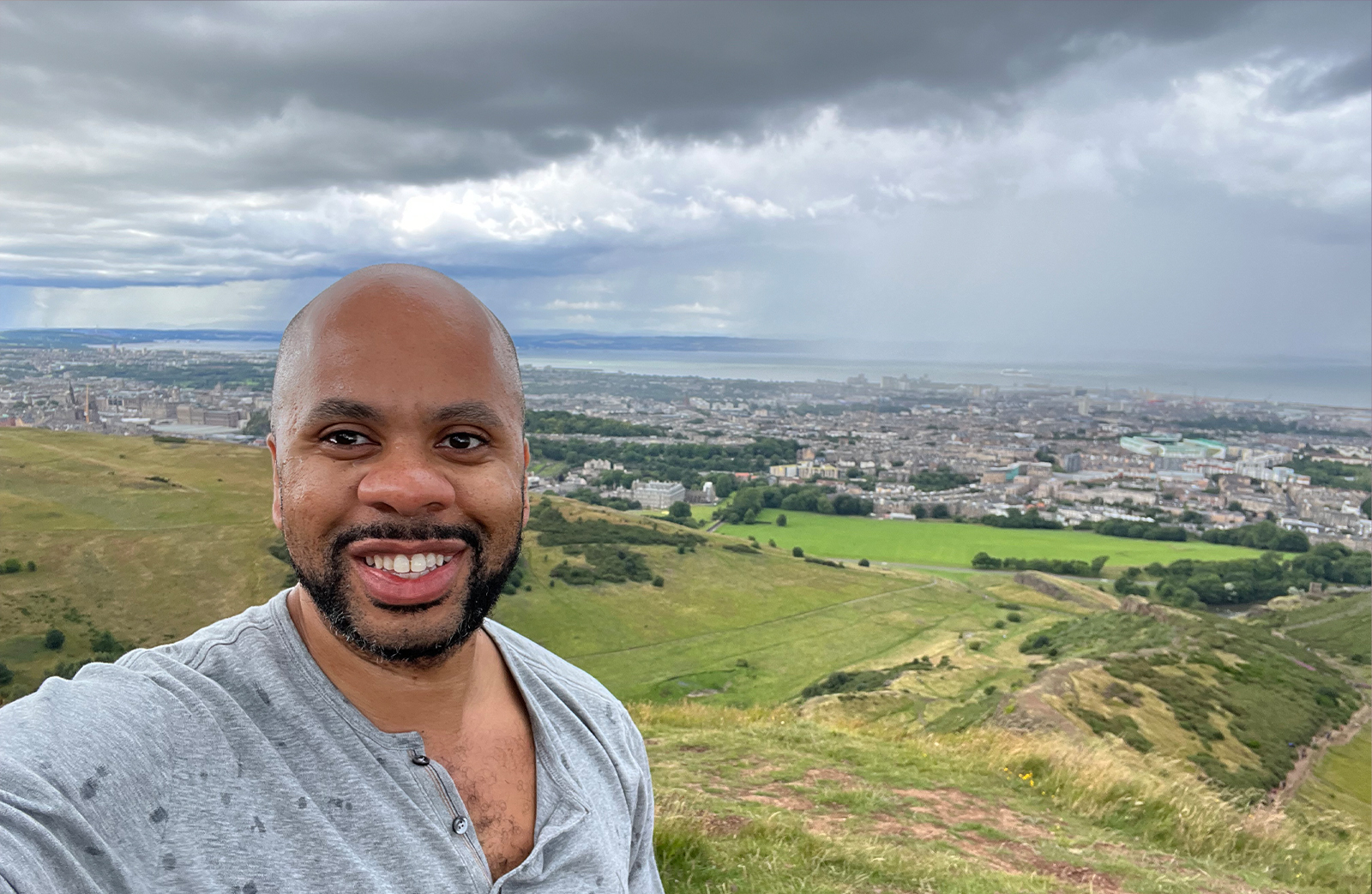 A selfie portrait of R. Eric Thomas on top of Arthur's Seat in Edinburgh.