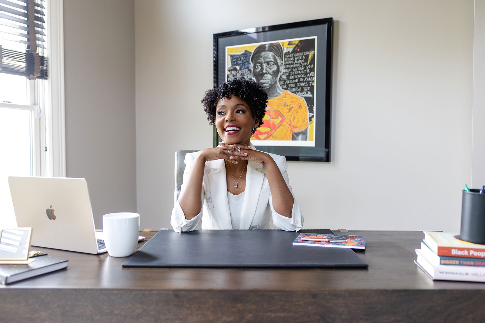 Maya sits at a desk in front of Bart Cooper's version of Harriet Tubman. Photo by Amanda Evans.