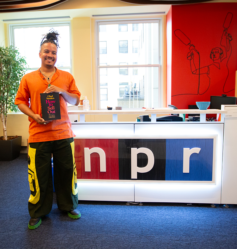 Chad Sanders smiling while holding a copy of 